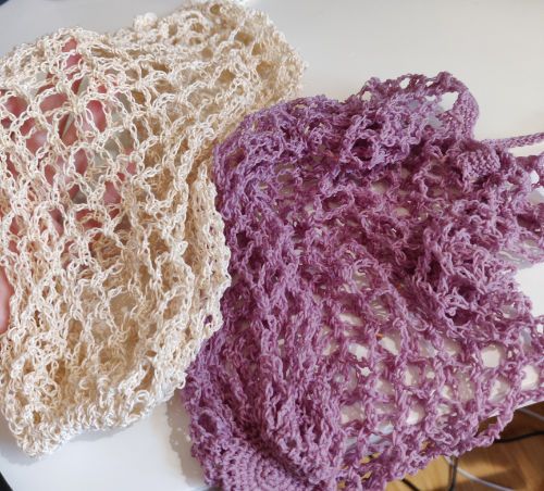 An undyed market bag next to a wet violet market bag